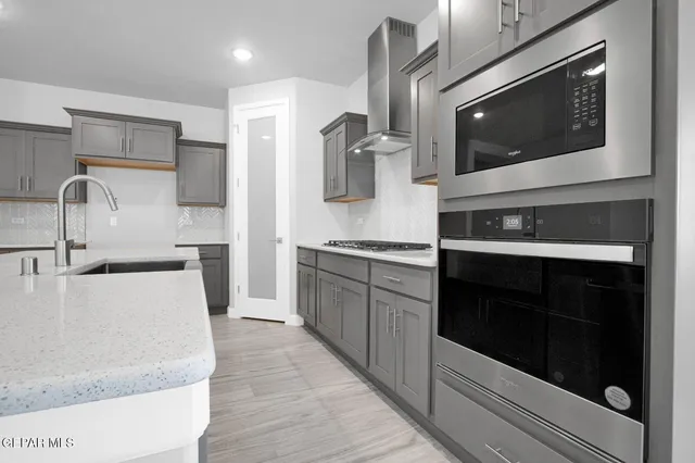 a kitchen with stainless steel appliances granite countertop a stove microwave and sink