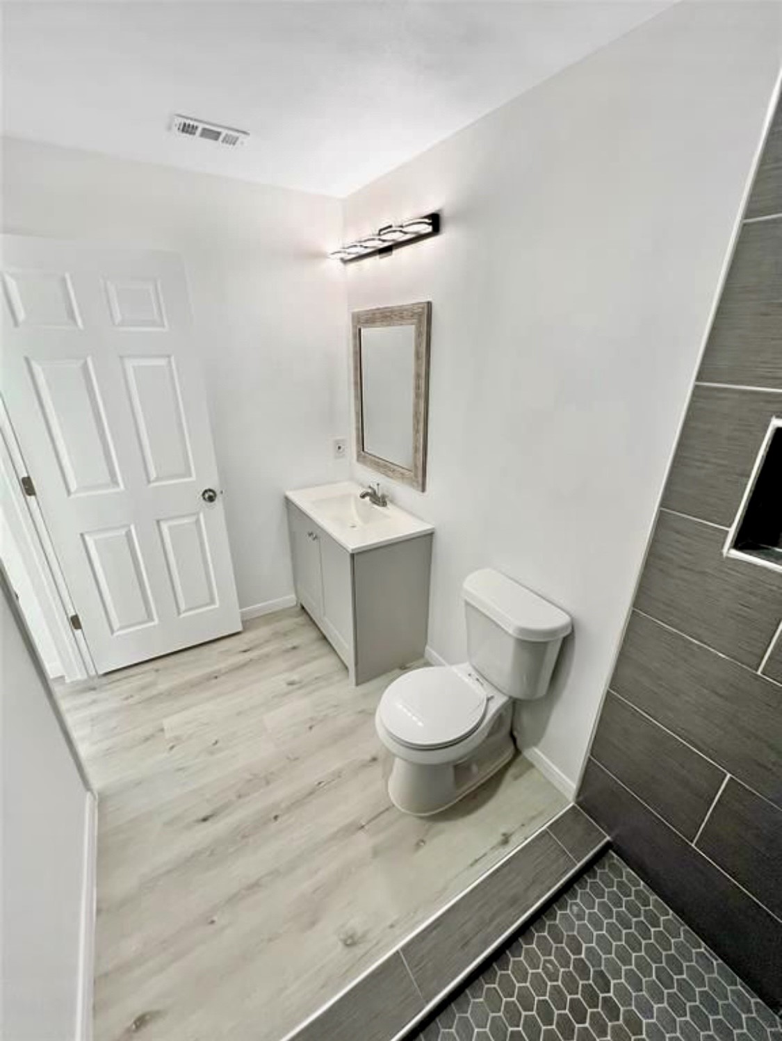 408 Commanche Road Conroe, TX 77316 - Photo 18 of 25 Modern bathroom featuring sleek tile flooring, a stylish vanity with a framed mirror, and a spacious shower area with contemporary fixtures.