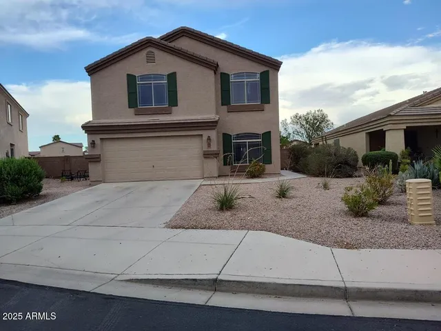 a front view of a house with garage and plants