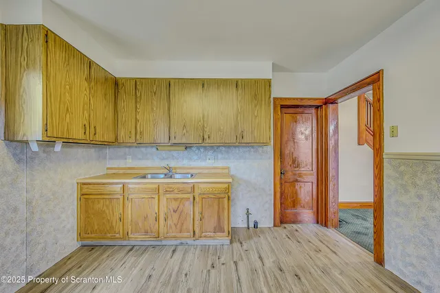 a room with a sink and wooden floor