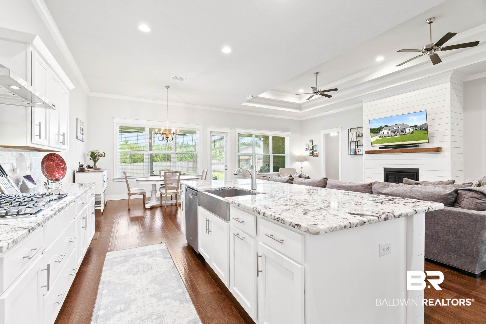 12785 Warbler Street Daphne, AL 36527 - Photo 52 of 53 Kitchen featuring white cabinetry, a fireplace, ornamental molding, open floor plan, and light stone counters