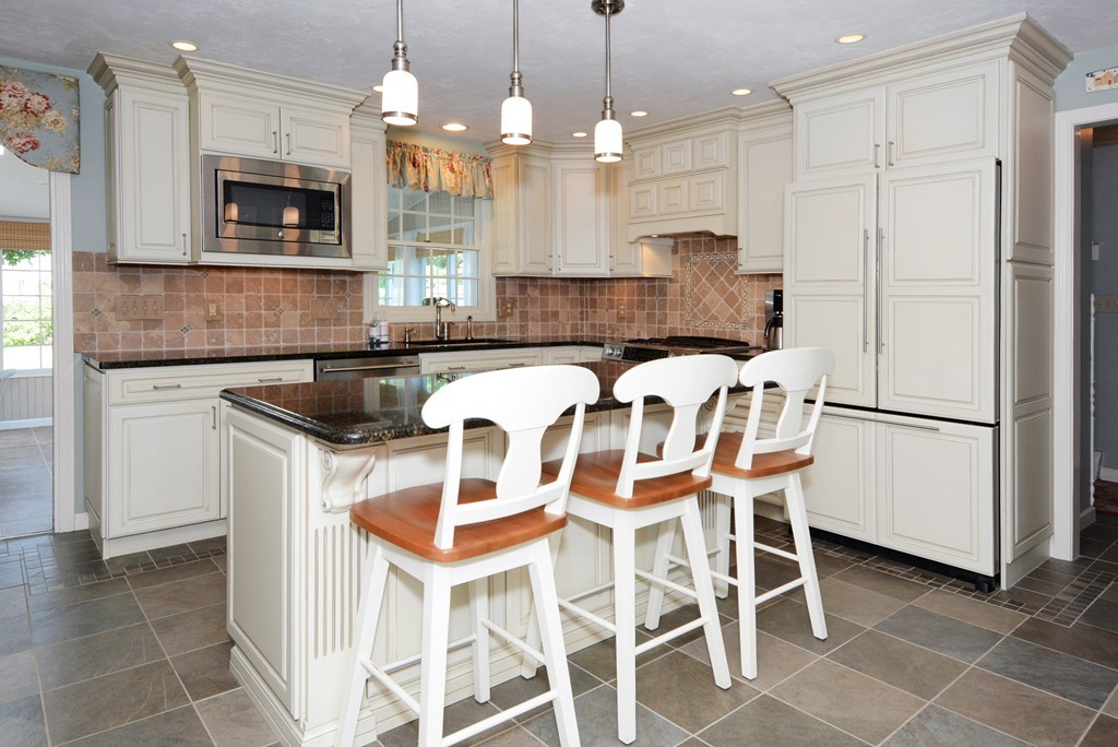 19 Lanthorn Road Northborough, MA 01532 - Photo 10 of 30 a kitchen with granite countertop a table chairs microwave and refrigerator