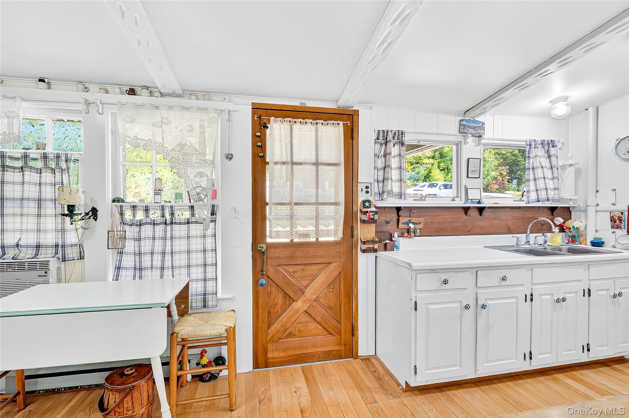 5 Orchard Road North Salem, NY 10509 - Photo 20 of 47 Kitchen featuring beam ceiling, light wood-style flooring, light countertops, white cabinetry, and a baseboard radiator