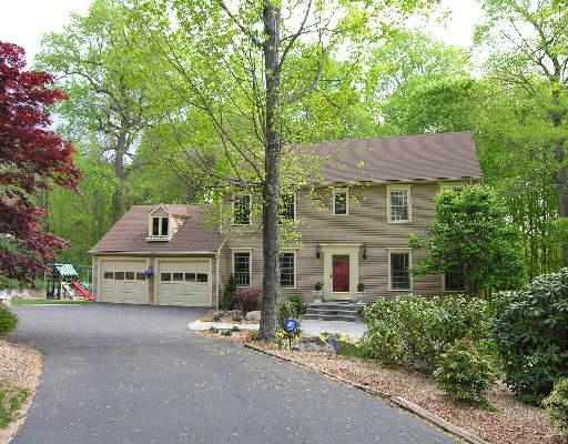 front view of a house with a garden and trees