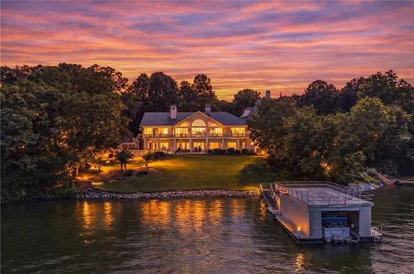 a view of a house with large windows and a yard