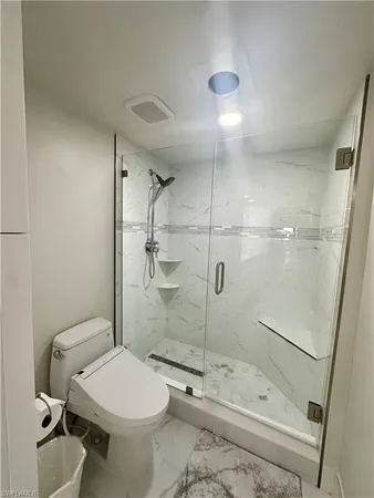 a white toilet sitting next to a bath tub and shower