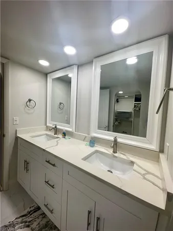 a bathroom with a granite countertop sink double and mirror
