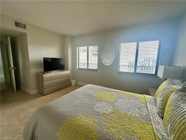 a bedroom with a large bed and a tv