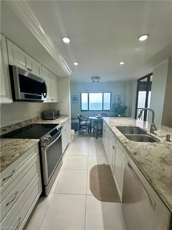 a kitchen with granite countertop a stove sink and microwave