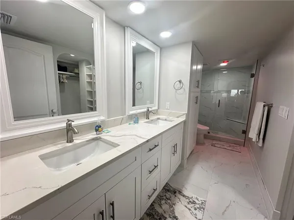 a spacious bathroom with double vanity and mirrors