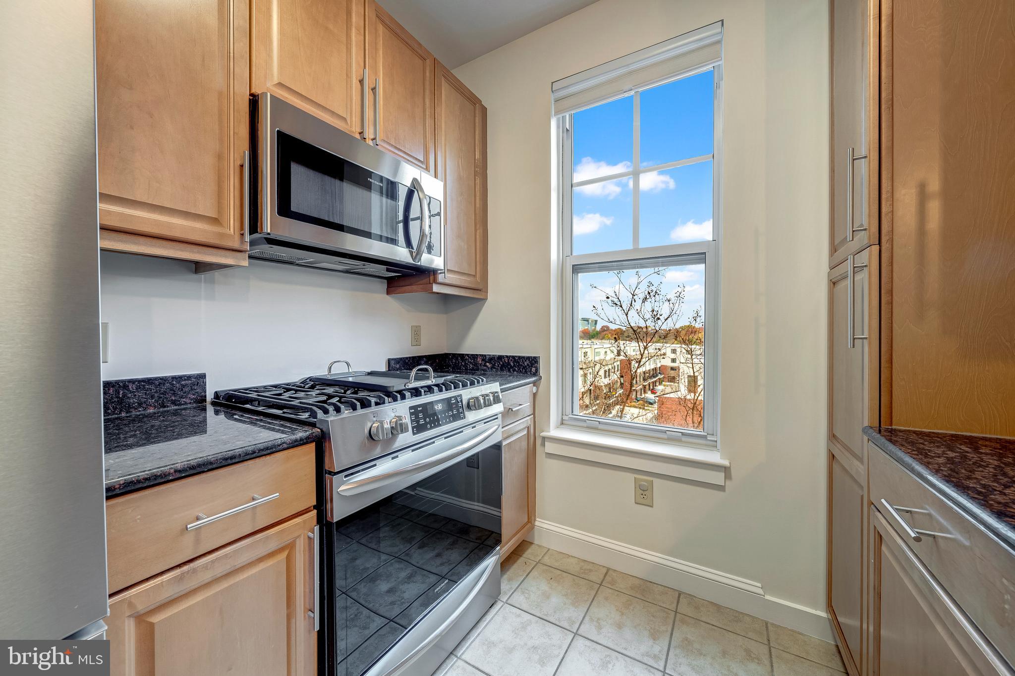 11770 Sunrise Valley Drive, Unit 321 Reston, VA 20191 - Photo 11 of 36 a kitchen with stainless steel appliances granite countertop a stove and a microwave
