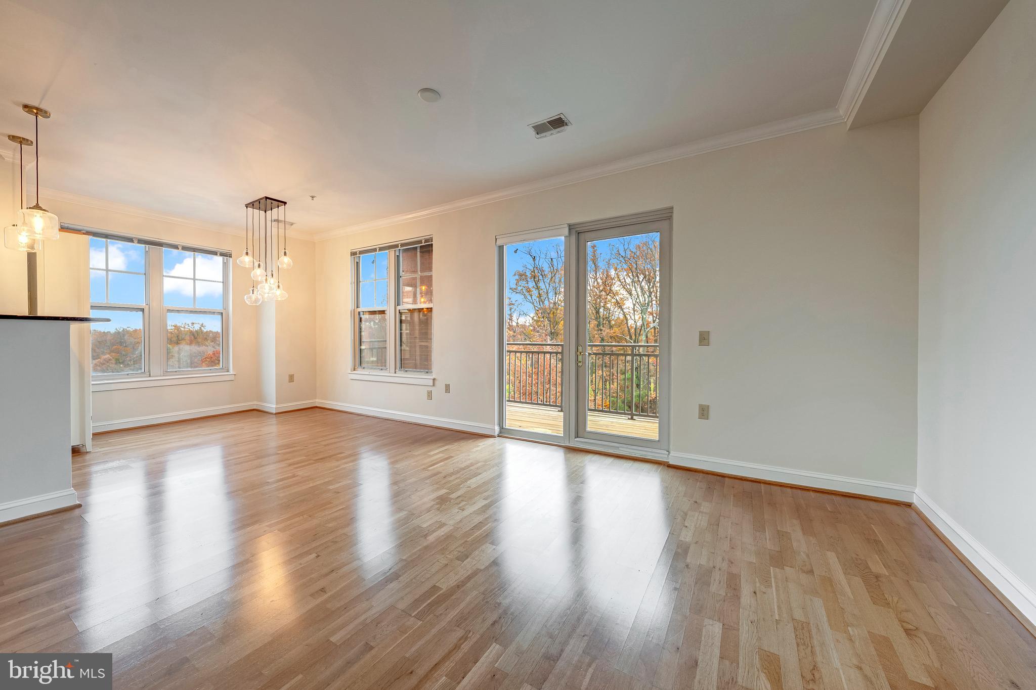 11770 Sunrise Valley Drive, Unit 321 Reston, VA 20191 - Photo 4 of 36 a view of an empty room with wooden floor and a window