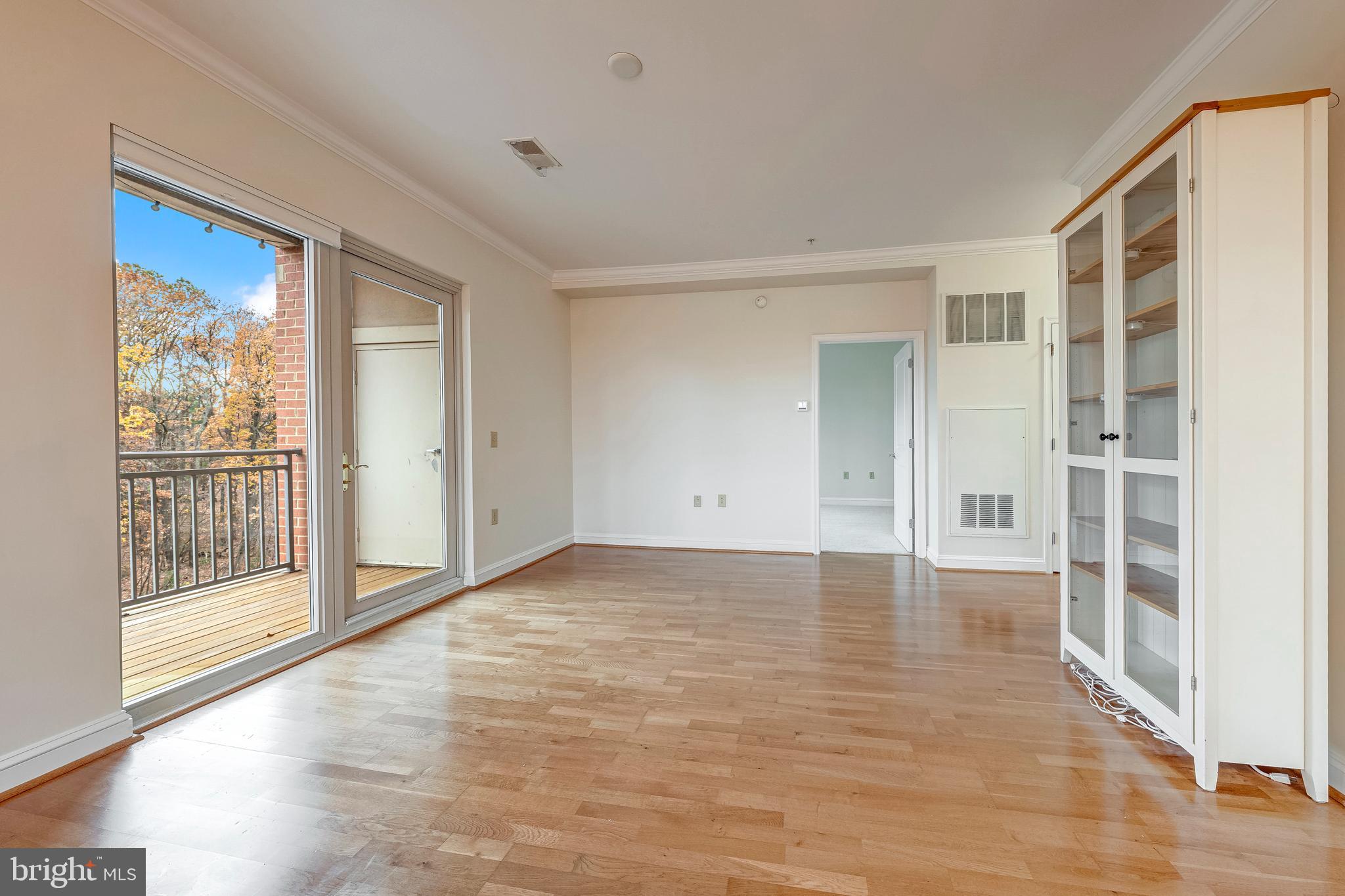 11770 Sunrise Valley Drive, Unit 321 Reston, VA 20191 - Photo 5 of 36 a view of an empty room with wooden floor and a window