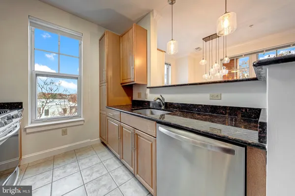 a kitchen with stainless steel appliances granite countertop a sink and a stove