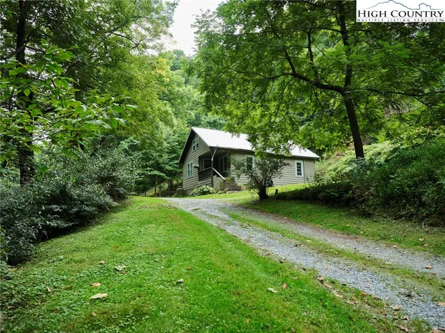 a view of a wooden house with a big yard