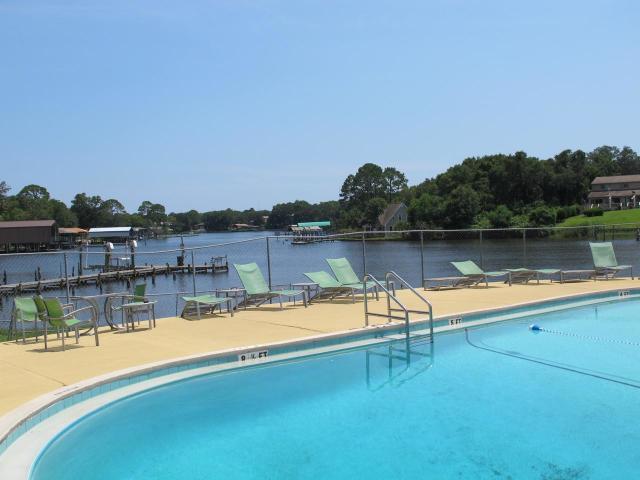 210 Pelham Road, Unit 114A Fort Walton Beach, FL 32547 - Photo 3 of 9 a view of a lake with a yard and large trees