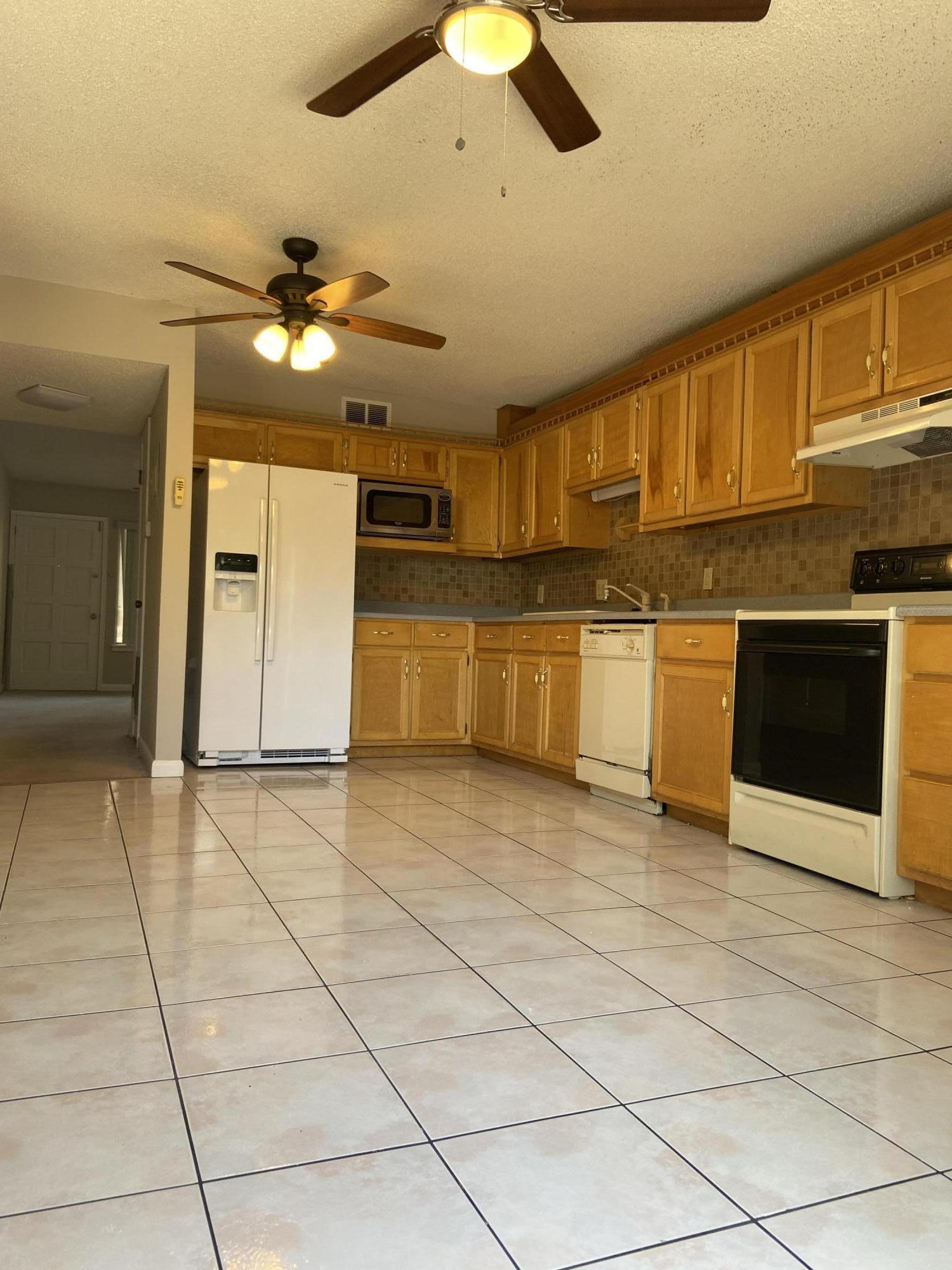 210 Pelham Road, Unit 114A Fort Walton Beach, FL 32547 - Photo 5 of 9 a view of a kitchen with an empty space cabinets and stainless steel appliances