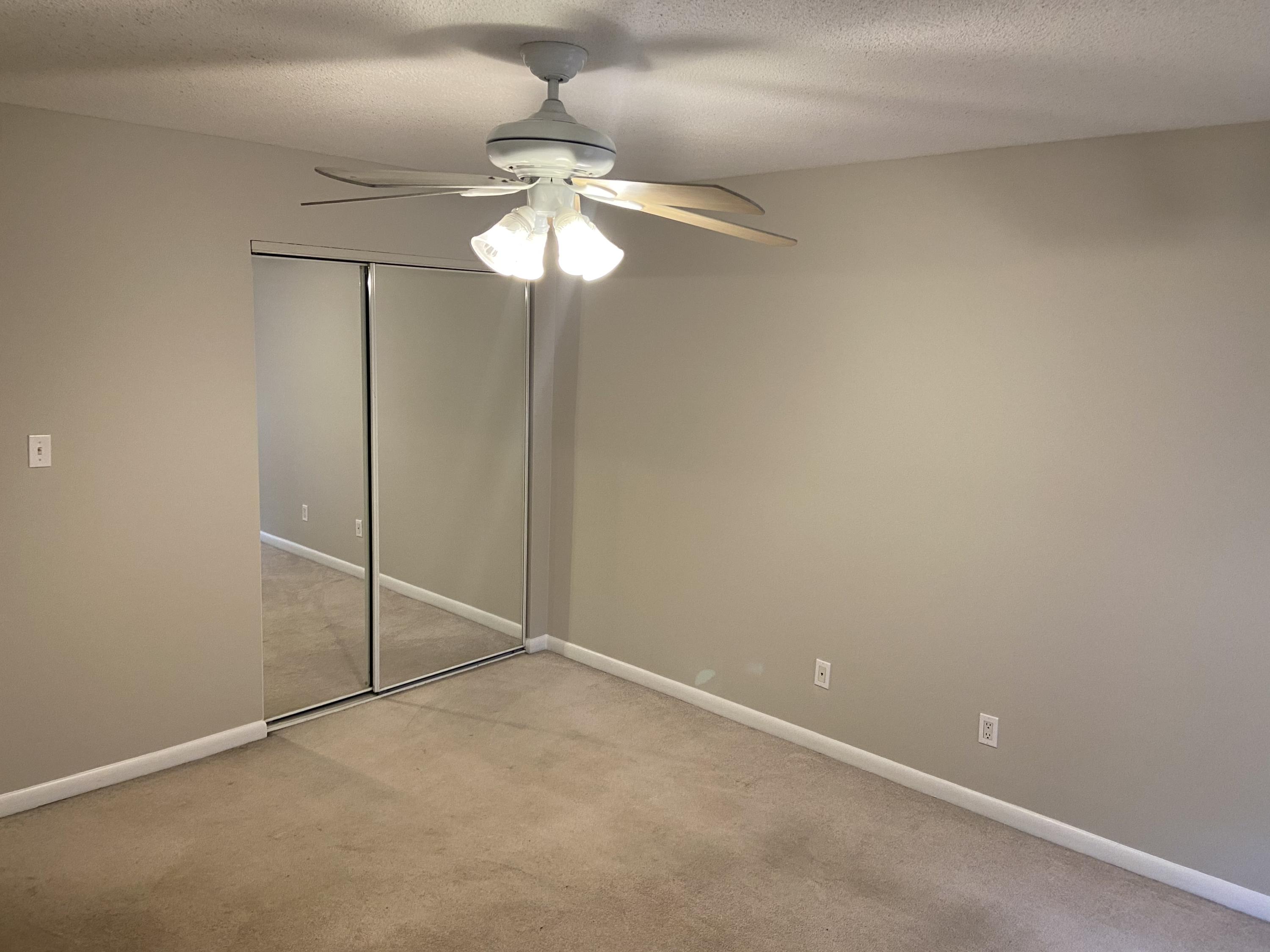 210 Pelham Road, Unit 114A Fort Walton Beach, FL 32547 - Photo 6 of 9 an empty room with a fan and a chandelier fan