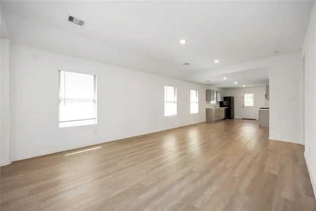 a view of empty room with wooden floor and window