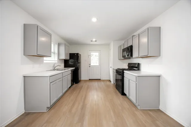 a kitchen with granite countertop white cabinets and white appliances