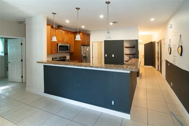 a large kitchen with a large counter top stainless steel appliances a chimney and a counter top