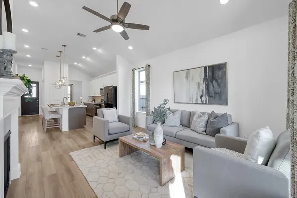 a living room with furniture kitchen view and a chandelier