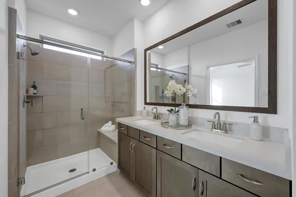 a bathroom with a shower sink vanity and mirror