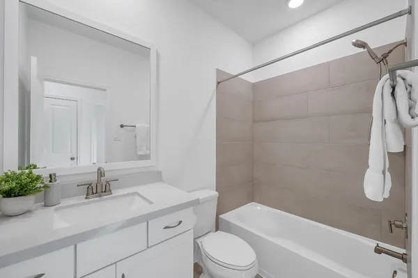 a bathroom with a granite countertop sink a toilet and shower