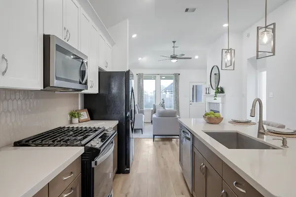 a kitchen with stainless steel appliances a sink stove and refrigerator