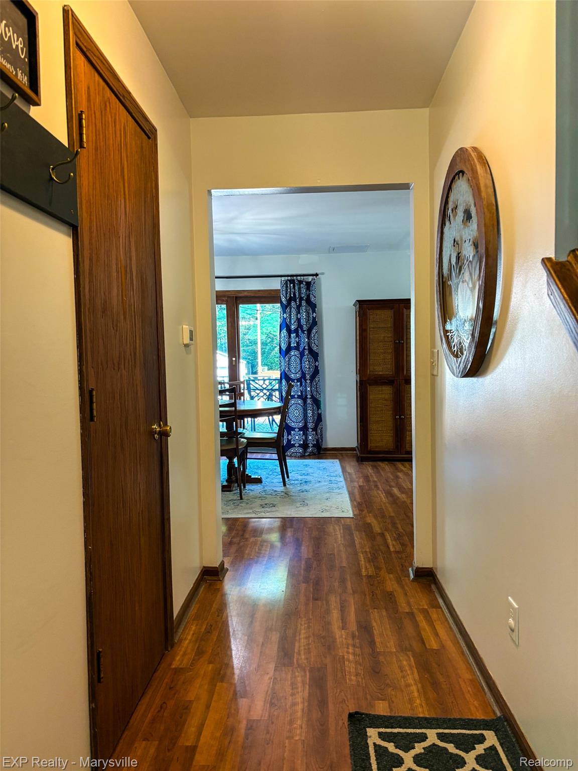 5538 Klettner Road St. Clair, MI 48079 - Photo 21 of 46 Hallway featuring wood-finish flooring, a solid core door, and a clear doorway opening to an additional room
