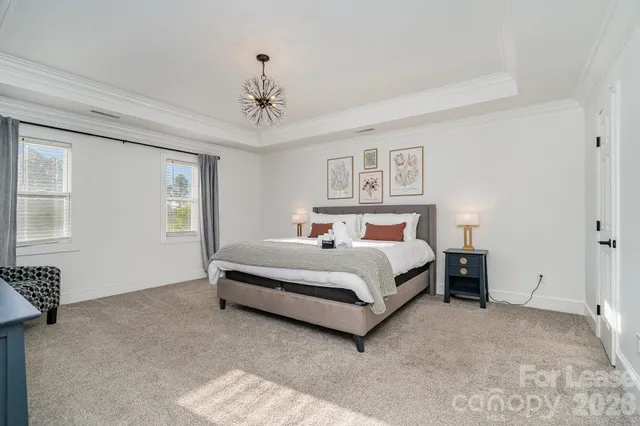 a bedroom with a large bed and a chandelier