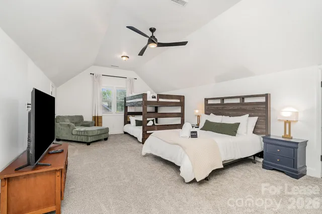 a spacious bedroom with a bed and a flat screen tv