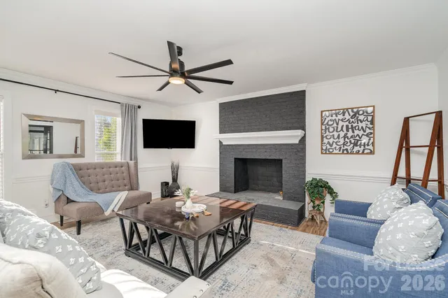 a living room with furniture a flat screen tv and a fireplace