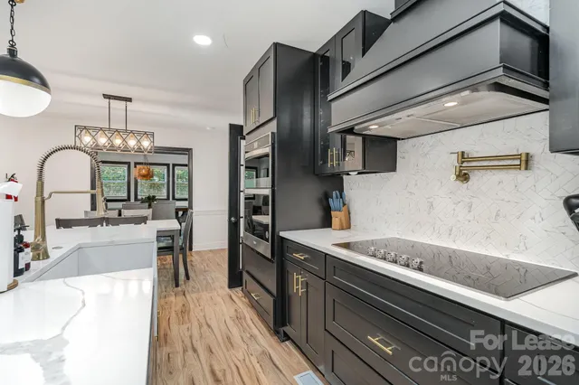 a kitchen with stainless steel appliances granite countertop a sink and a stove
