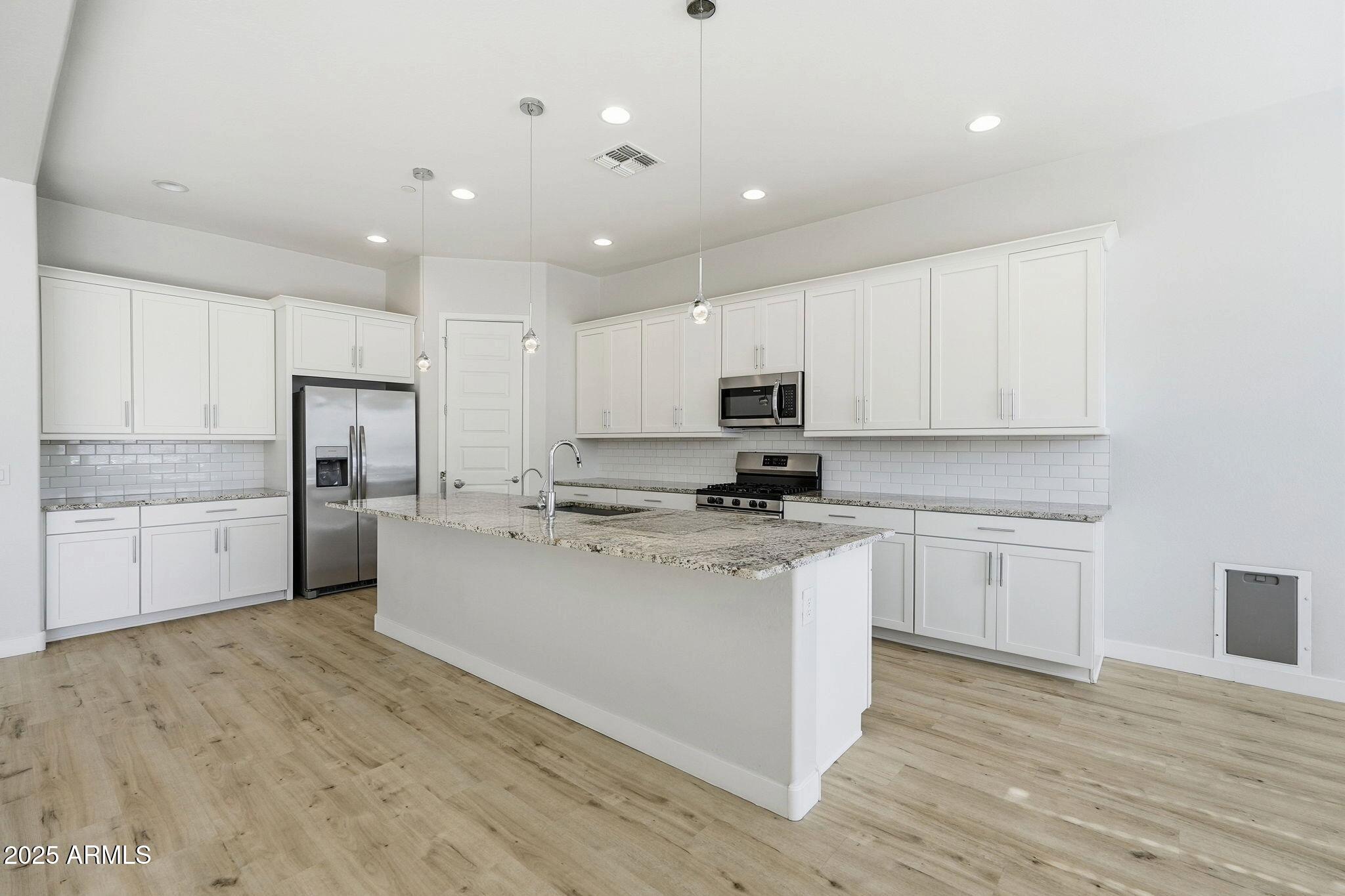 9749 East Tahoe Avenue Mesa, AZ 85212 - Photo 1 of 41 a kitchen with stainless steel appliances granite countertop a stove top oven a sink and white cabinets