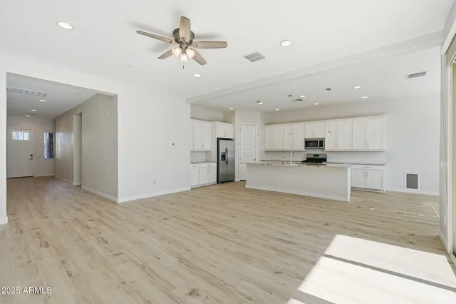 a view of kitchen with kitchen island white cabinets and refrigerator