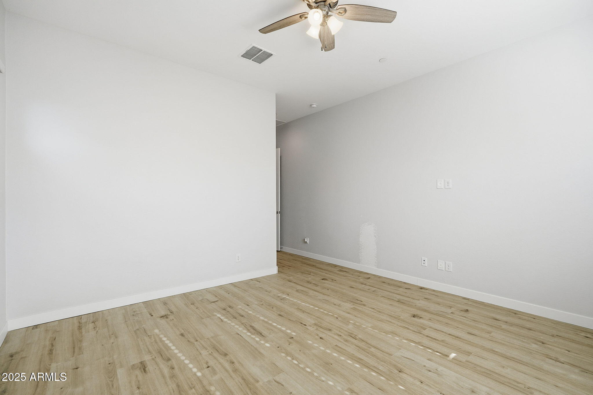 9749 East Tahoe Avenue Mesa, AZ 85212 - Photo 9 of 41 an empty room with a chandelier fan and wooden floor
