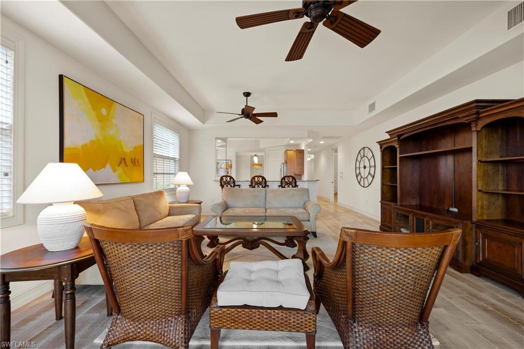 8613 Champions Point, Unit 302 Naples, FL 34113 - Photo 12 of 41 a living room with furniture and a lamp