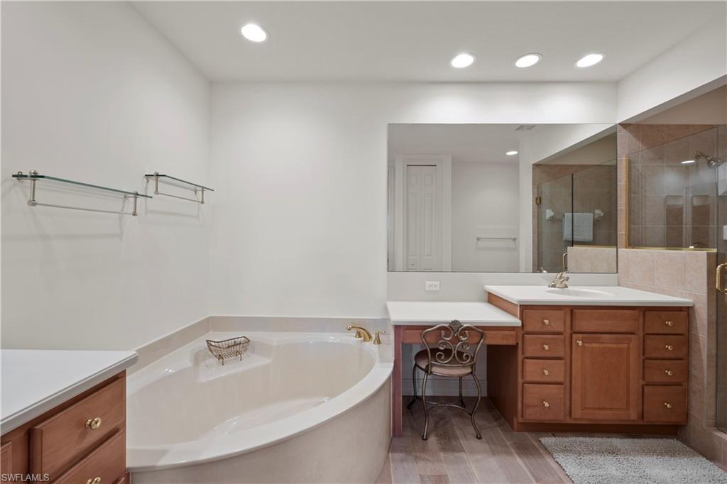 8613 Champions Point, Unit 302 Naples, FL 34113 - Photo 18 of 41 a bathroom with a tub a sink and mirror