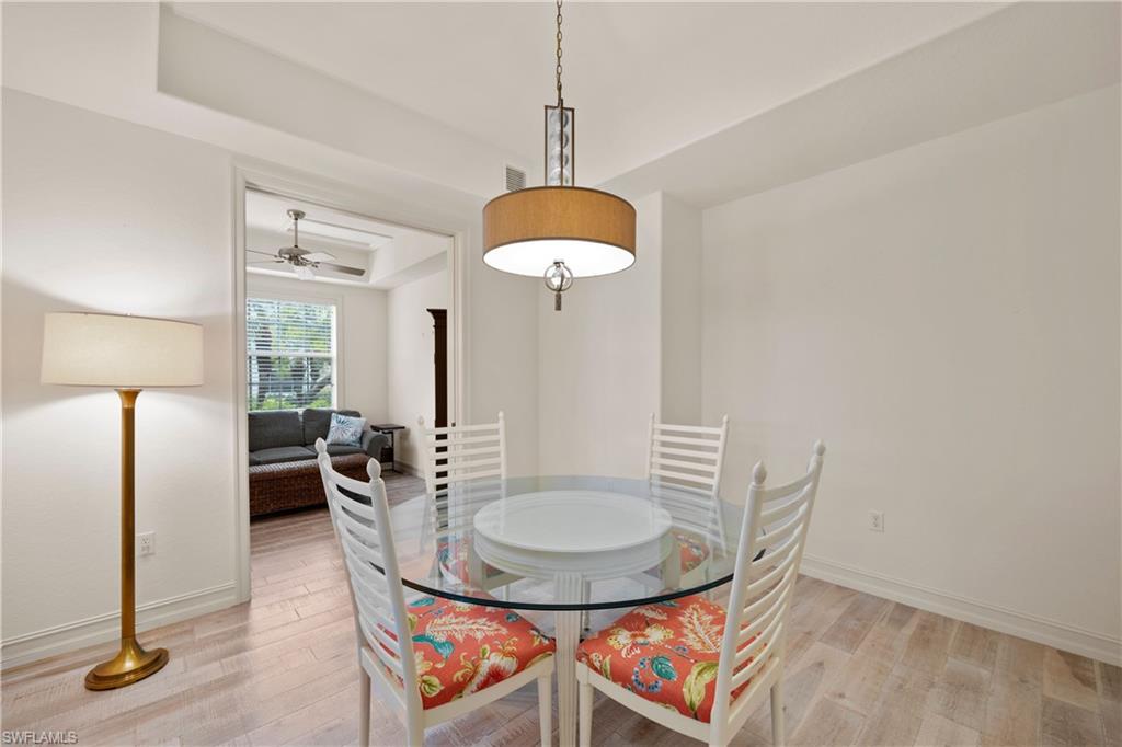 8613 Champions Point, Unit 302 Naples, FL 34113 - Photo 20 of 41 a dining room with furniture and a chandelier