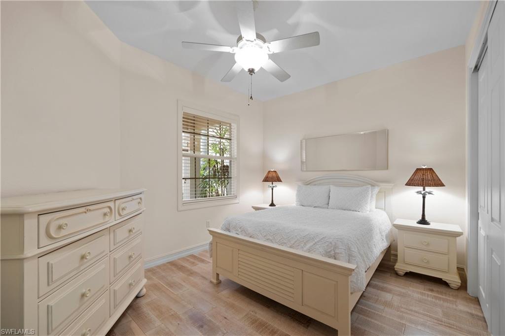8613 Champions Point, Unit 302 Naples, FL 34113 - Photo 22 of 41 a bedroom with a bed and a chandelier