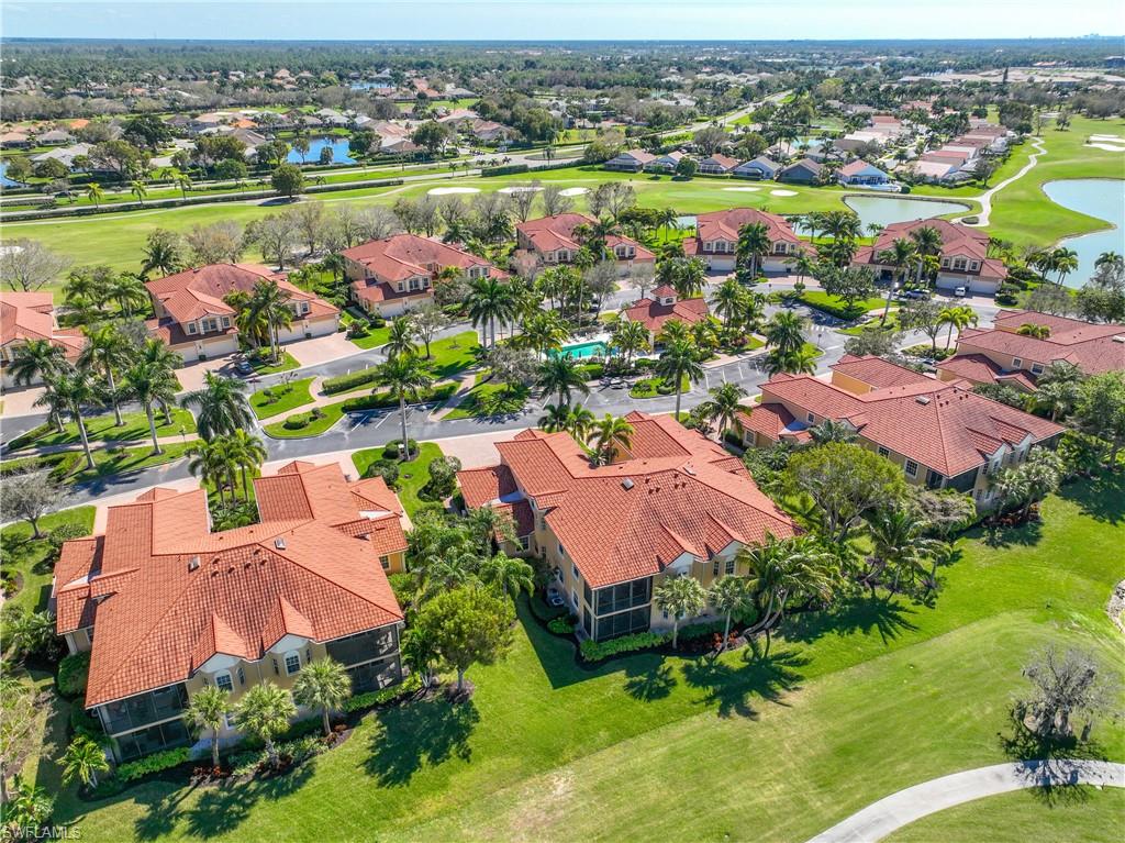 8613 Champions Point, Unit 302 Naples, FL 34113 - Photo 31 of 41 an aerial view of a houses with a lake and a mountain