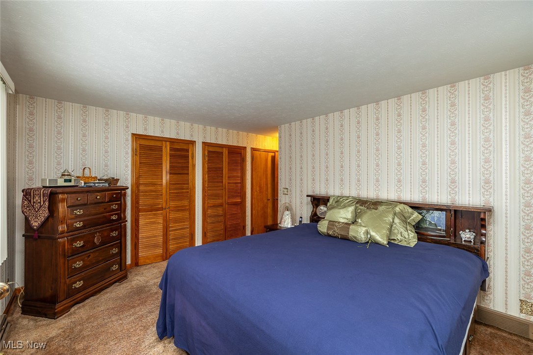 750 Sagamore Road Northfield, OH 44067 - Photo 18 of 37 Bedroom with light carpet, multiple closets
