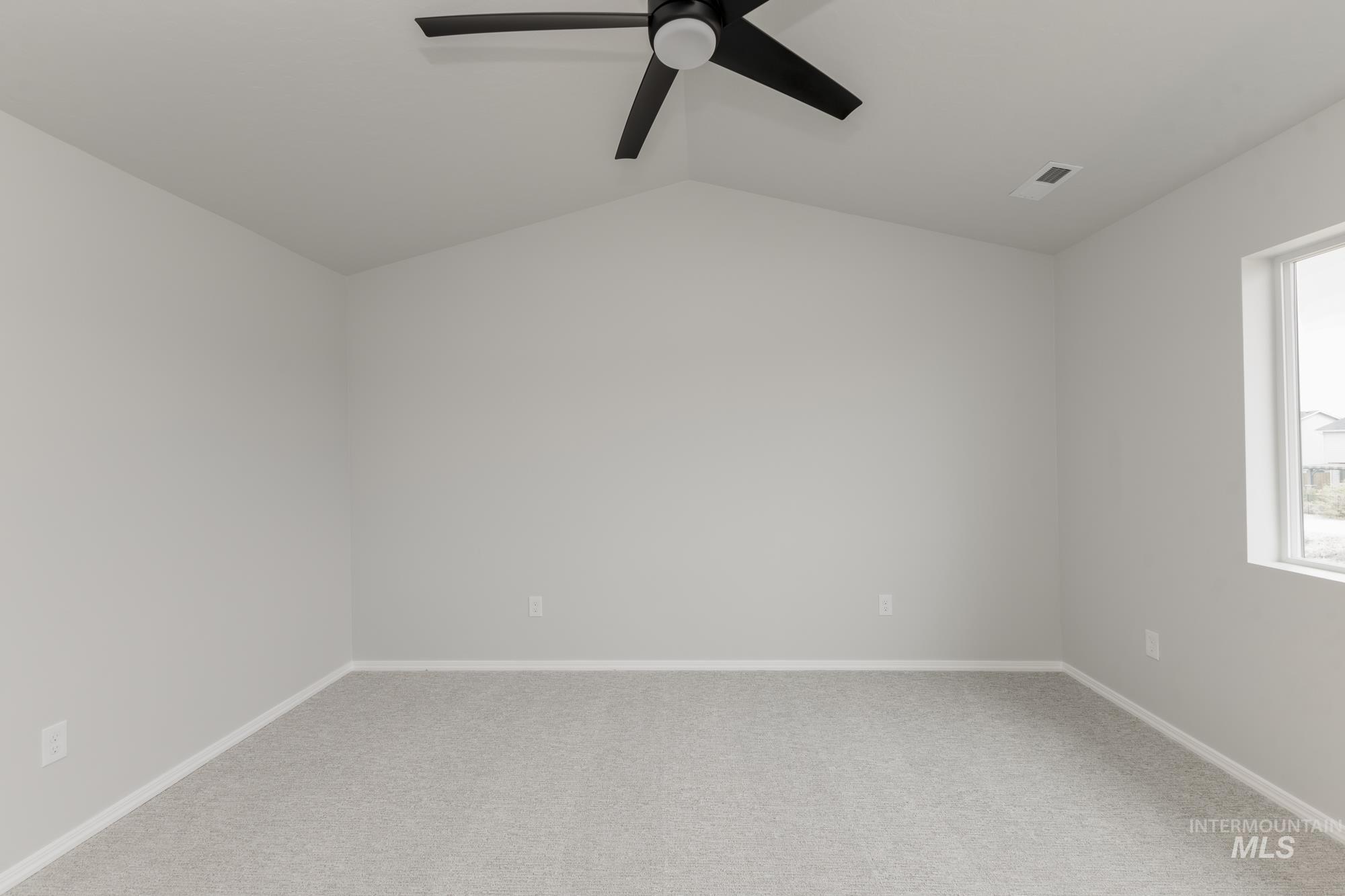12842 Ropers Street Nampa, ID 83651 - Photo 24 of 29 Carpeted room featuring a vaulted ceiling with a black ceiling fan, white baseboards, and a window with white trim