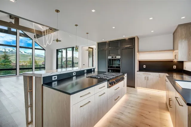 a large kitchen with granite countertop a sink and a stove top oven