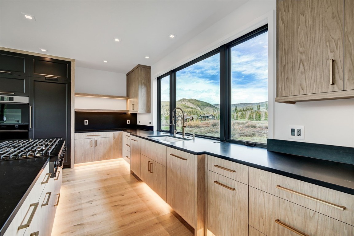 294 Gold Run Road Breckenridge, CO 80424 - Photo 17 of 50 a large kitchen with granite countertop a stove a sink a refrigerator and white cabinets with wooden floor