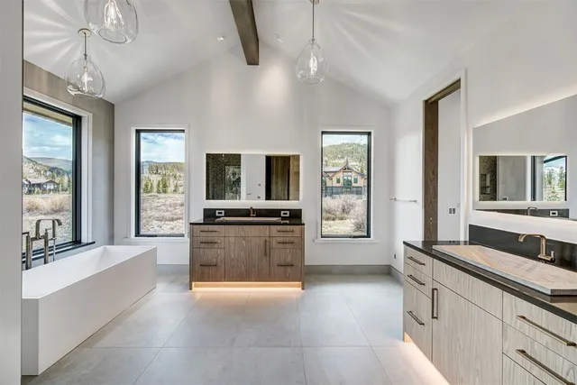 a large white kitchen with cabinets a sink and a window