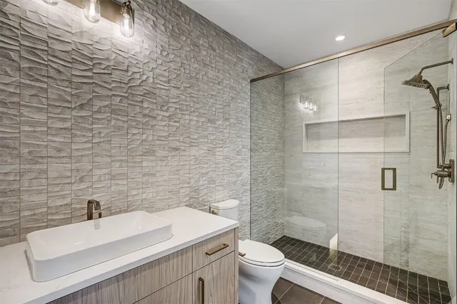 a bathroom with a sink a toilet and shower