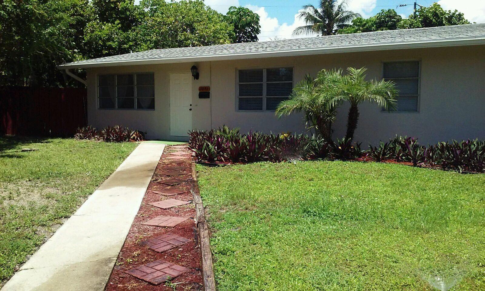 1071 Northeast 4th Avenue Boca Raton, FL 33432 - Photo 1 of 4 a front view of a house with a yard