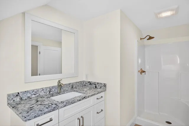 a bathroom with a granite countertop sink and a mirror